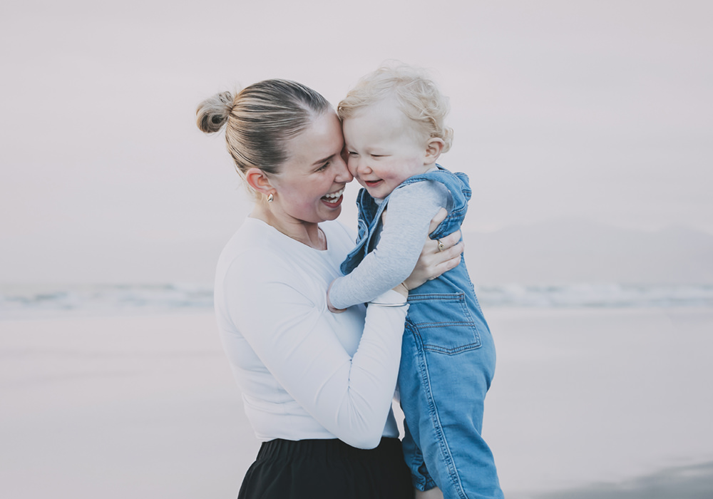 Mother and Son cuddles on the beach in Italy, a great location for family portraits