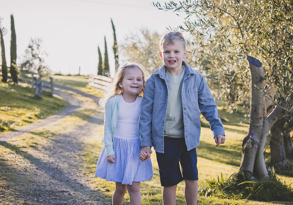 Family portraits Italy olive grove and cypress trees with siblings