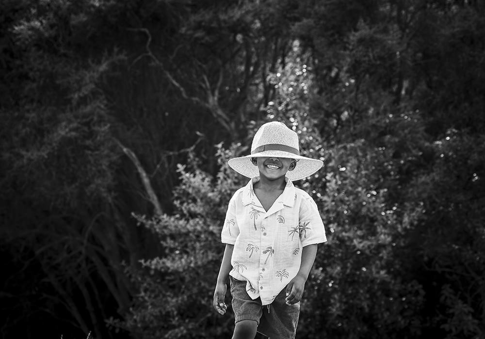 Fun portraits in Italy with a child and his hat, ideas for things to do with children in Italy on vacation